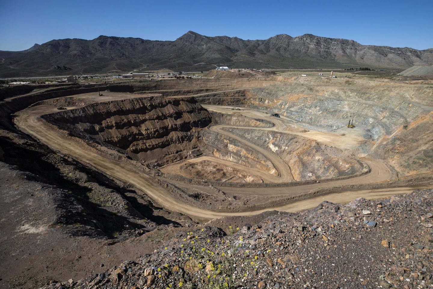 Mining equipment sits inside the pit at the Mountain Pass mine, operated by MP Materials, in Mountain Pass, California, U.S. America's top rare earths producer, MP Materials, is expanding its vertical integration of mining and magnets production in the U.S. after years of shipping its output to China because there was no refining capacity available to handle its production. Photographer: Joe Buglewicz/Bloomberg via Getty Images