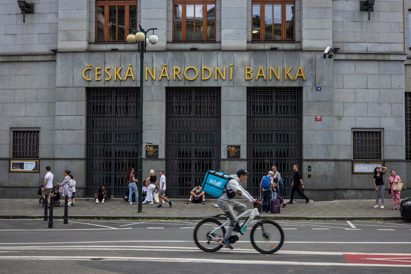 a cyclist rides by a building in prague